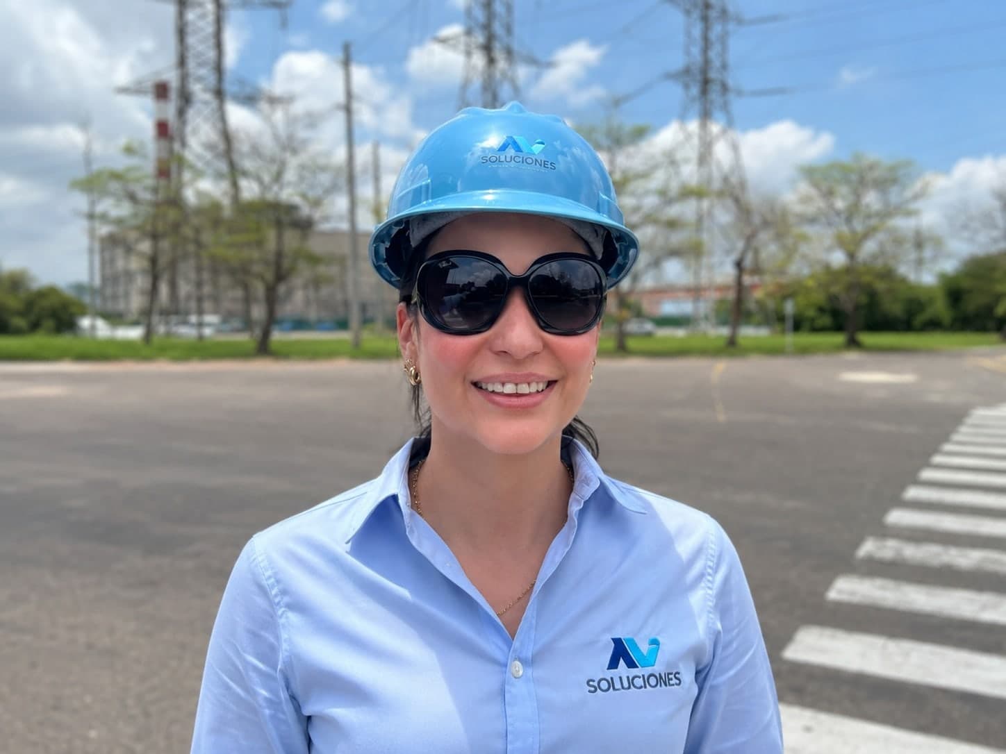 Integrante de AV Soluciones con casco y camisa de la marca, en una subestación eléctrica